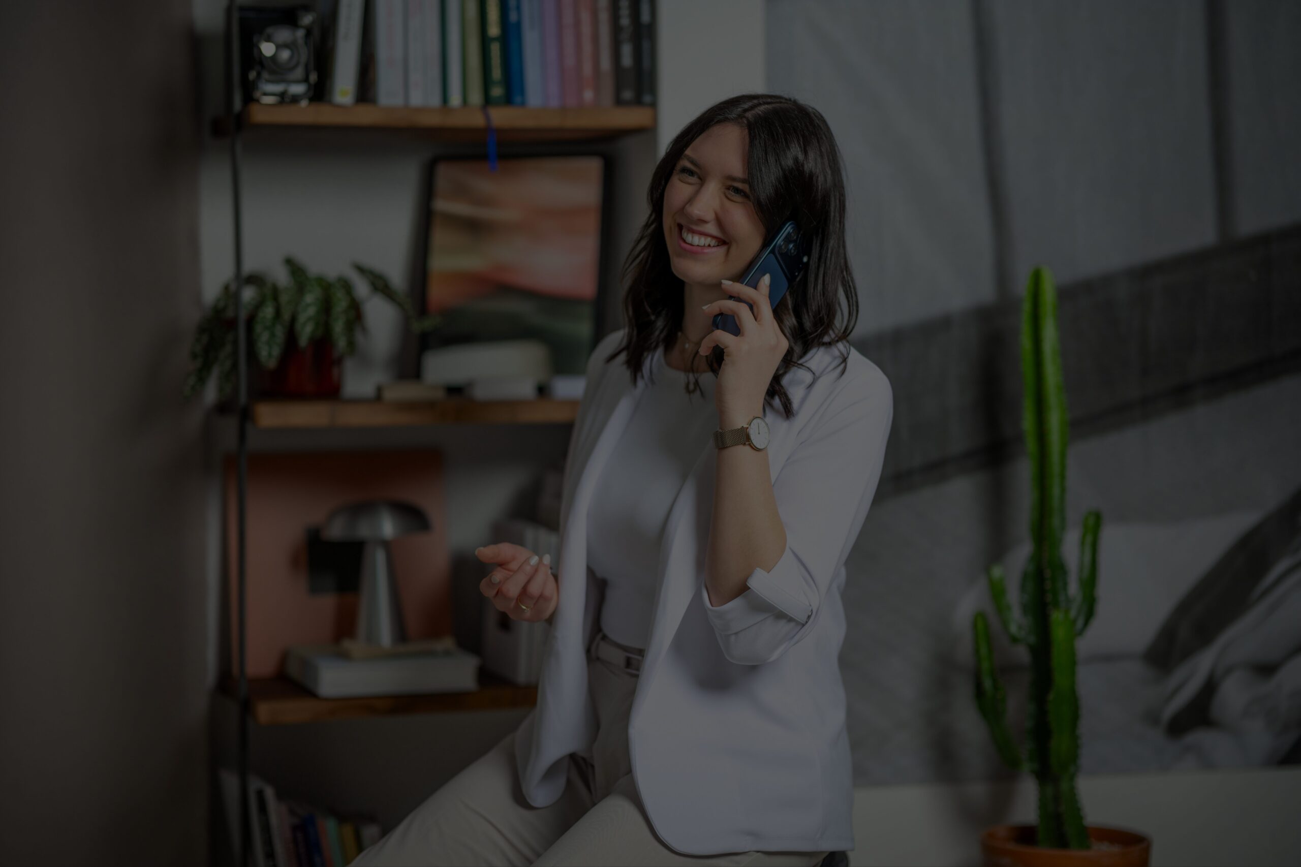 Copywriterin pflegt ihre Kontakte und telefoniert mit einem Lachen im Gesicht.